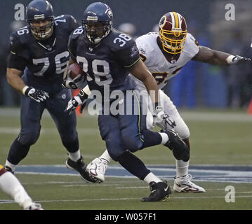 Seattle Seahawks fullback Mack forte , centro, corre per brevi yardage come Washington Redskins' Phillip Daniels ,destra, segue durante il primo trimestre di NFL azione a Seattle il 14 gennaio 2006. Seahawks Steve Hutchinson orologi (UPI foto/Jim Bryant) Foto Stock