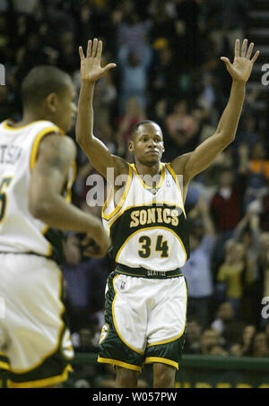 Seattle Supersonics' Ray Allen (34) solleva le braccia nel secondo trimestre dopo la rottura della stagione unica a tre punti con record 268 presso la Key Arena di Seattle del 19 aprile 2006. Earl Watson, sinistra, alimentato Allen la palla per i tre punti di gioco. (UPI foto/Jim Bryant) Foto Stock