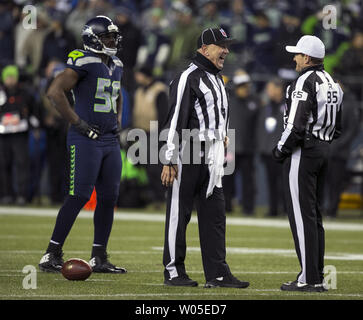 La linea Giudice John Hussey (L) e arbitro ed Hochuli (85) condividono un momento più leggero durante un time out nel quarto trimestre del Seattle Seahawks New Orleans Saints partita al campo CenturyLink a Seattle, Washington il 2 dicembre 2013. Il Seahawks divenne la prima squadra a conquistare un posto nei playoff NFC con un 34-7 vittoria su New Orleans Saints. UPI /Jim Bryant Foto Stock