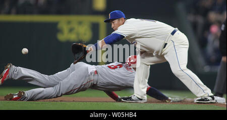 Seattle Mariners' primo baseman Norichika Aoki raggiunge per una sfera durante un passo del rilevatore come Los Angeles Angeli runner base Yunel Escobar scorre tranquillamente indietro nel primo inning Maggio15, 2016 al Safeco Field di Seattle. Foto di Jim Bryant/ UPI foto Foto Stock