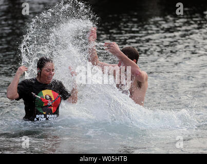 Blake Awes schizzi Dianne Bauer dopo aver saltato il ponte nel Burley laguna durante la xxxiii annuale orso polare su Gennaio 1, 2017 in Olalla, Washington. Oltre 400 hardy partecipanti alla annuale sul primo giorno del nuovo anno la tradizione saltando in le fredde acque della laguna durante l'orso polare tuffo. Foto di Jim Bryant/UPI Foto Stock