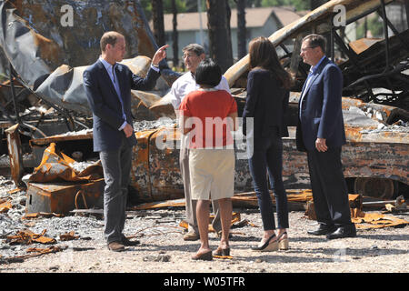 Sindaco Karina Pillay-Kinee (maglione rosso) accompagnatrici il principe William e sua moglie Kate, il Duca e la Duchessa di Cambridge, in una passeggiata attraverso un incendio di foresta zona devastata durante la loro visita improvvisata a Slave Lake, Pillay-Kinee piccolo Albertan settentrionale comunità, Luglio 6, 2011. UPI/hr/patrimonio di cortesia in Canada Foto Stock