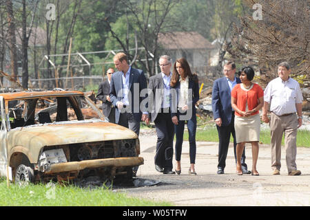 Sindaco Karina Pillay-Kinee (maglione rosso) accompagnatrici il principe William e sua moglie Kate, il Duca e la Duchessa di Cambridge, in una passeggiata attraverso un incendio di foresta zona devastata durante la loro visita improvvisata a Slave Lake, Pillay-Kinee piccolo Albertan settentrionale comunità, Luglio 6, 2011. UPI/hr/patrimonio di cortesia in Canada Foto Stock