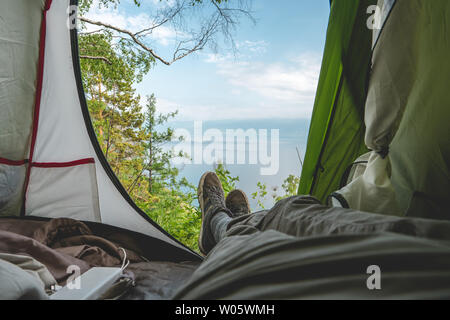 Vista dalla tenda sul lago Baikal tra i pini dalla collina. Il concetto di turismo e ricreazione nei luoghi più belli del pianeta Foto Stock