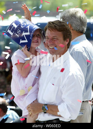 Morsa democratico il candidato presidenziale John Edwards mantiene la sua figlia Emma Claire come scudi ha la sua testa da residui di carta durante un rally a San Louis Union Station sulla loro whistle stop viaggio in treno attraverso il Missouri il 5 agosto 2004. (UPI foto/Bill Greenblatt) Foto Stock