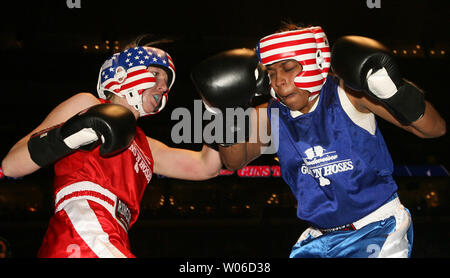 Kelly Hunsel del San Carlo, Missouri Vigili del Fuoco (L) offre una sinistra alla faccia di Jackie Jones di Berkeley, Missouri dipartimento di polizia durante il secondo turno delle pistole e i tubi flessibili Boxing Showdown al Scottrade Center di San Luigi il 21 novembre 2007. Il pugilato partite sono tenuti ogni anno per raccogliere fondi per Backstoppers, un orginization che consente alle famiglie di poliziotto e vigili del fuoco uccise nella linea di azione. (UPI foto/Bill Greenblatt) Foto Stock