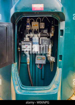 Vista del sistema di erogazione del carburante su un arlecchino provvista di elementi di contenimento diesel rosso serbatoio di stoccaggio Foto Stock