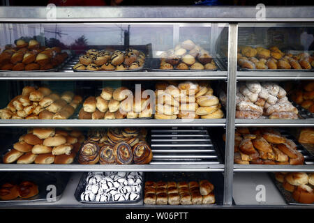 Foto di un assortimento di pane appena sfornato e dolci sul visualizzatore in corrispondenza di un bakeshop Foto Stock