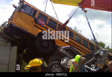 Un opere di gru per il sollevamento di una scuola bus off della parte posteriore di un rimorchio di un trattore in seguito ad un incidente nei pressi di Washington, Missouri sulla Interstate 44, dove due persone sono state uccise il 5 agosto 2010. Polizia di Stato dire il trattore rimorchio frenato per la costruzione quando un pickup truck sbattuto nella parte posteriore del carrello. Una scuola gli autobus che trasportano alta scuola i bambini da San Giacomo, Missouri al Six Flags Amusement Park e poi colpire il pickup truck uccidere quel driver. Un secondo bus di scuola da parte dello stesso gruppo colpito il primo autobus uccidendo una ragazza studente di equitazione in retro. Circa una cinquantina di studenti sono stati trasportati al San Loui Foto Stock