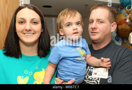 Due anni di Owen Stark in posa per una fotografia con la sua madre Tonya e padre Justin nella sua stanza di ospedale in ospedale per bambini in San Luigi il 27 agosto 2010. Stark che soffre di ipertensione arteriosa polmonare, una malattia in cui le navi dai polmoni al cuore sono così ristretti che il flusso di sangue è difficile, diventa la persona più giovane al mondo ad essere impiantato con un polmone artificiale. Il dispositivo chiamato NovaLung, utilizza tubi impiantati nel torace per far circolare il sangue, mentre una casella al di fuori del corpo agisce come una sostituzione del polmone. I medici presso l'Ospedale chiesero la FDA per utilizzare N Foto Stock