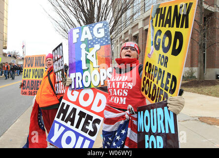 Due membri dal Westboro Baptist Church di Topeka nel Kansas, iniziano i loro canti su un angolo di strada in San Carlo, Missouri come quelle in disaccordo con le loro opinioni, a piedi giù per la strada per salutare il 6 gennaio 2011. La Chiesa che predica contro ogni forma di peccato è noto per mostrare fino a funerali militare di guidare a casa loro anti-gay-punto. San Carlo contea ha approvato una legge che la Westboro Baptist Church i dimostranti devono essere almeno 300 piedi da qualsiasi funerale militare o di sepoltura. La legge è ora essendo challanged nella corte federale dall'ACLU. UPI/Bill Greenblatt Foto Stock