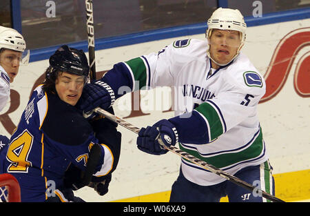 Vancouver Canucks Christian Ehrhoff (5) dà San Louis Blues TJ Oshie un puch alla faccia del primo periodo al Scottrade Center di San Luigi il 14 febbraio 2011. UPI/Bill Greenblatt Foto Stock