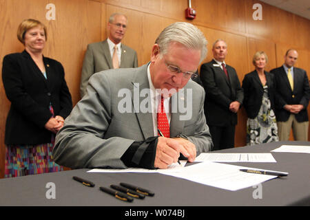 In veste di legislatori a guardare, Missouri governatore Jay Nixon segni bollette casa 1172, 1576 e 1577 che sarà in grado di supportare foster care i genitori e i bambini e per aiutare le agenzie di assistenza che forniscono servizi di assistenza residenziale e il trattamento per il Missouri la gioventù di Webster Groves, Missouri il 25 giugno 2012. UPI/Bill Greenblatt Foto Stock