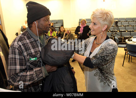 Brenda Warner, moglie dell'ex NFL quarterback Kurt Warner dà una mano al veterano Donnie Jones durante il primo giorno di distribuzione della Warner's Warm-Up coat drive presso il San Patrizio Center di San Luigi il 12 novembre 2013. Si svolge ogni anno a partire dal 2001, il dolce-utilizzato cappotti sono date a coloro che sono nel bisogno, fornendo cappotti per oltre 150.000 data. UPI/Bill Greenblatt Foto Stock