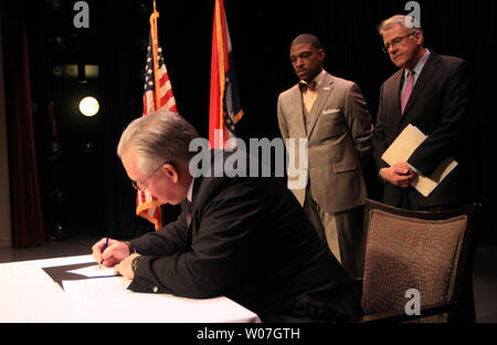 Missouri governatore Jay Nixon firma un ordine esecutivo che istituisce la Commissione Ferguson a St Louis il 18 novembre 2014. Il Ferguson Commissione esaminerà le questioni fondamentali sollevate dagli eventi di Ferguson e il rilascio di un rapporto con specifiche raccomandazioni politiche il sedici uomini e donne giurato in sono composte di proprietari di imprese non-profit di dirigenti, insegnanti, avvocati, funzionari di polizia, attivisti, pastori e funzionari pubblici. Cerca su è co-presidenti Rev. Starsky Wilson (L) e ricca McClure. UPI/Bill Greenblatt Foto Stock