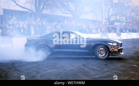 Appassionati di godere il rumore e il fumo dalla Ford Mustang del conducente Vaughn Gittin Jr durante una dimostrazione di drifting al St. Louis Auto Show di San Louis il 24 gennaio 2015. Foto di Bill Greenblatt/UPI Foto Stock