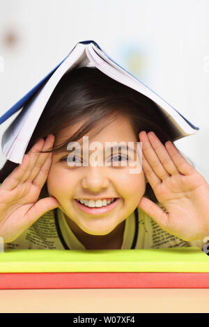 Ritratto di una ragazza con il libro sulla sua testa Foto Stock