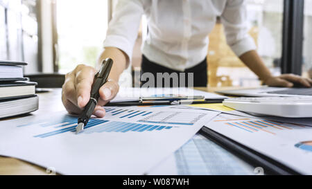 Business donna contabile che lavora e calcolando i dati finanziari sul grafico documenti, facendo finanziare in workstation. Foto Stock