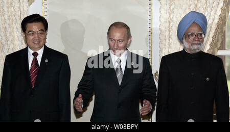 Il presidente russo Vladimir Putin (C) accoglie favorevolmente il presidente cinese Hu Jintao (L) e il Primo Ministro indiano Manmohan Singh nella sessione finale del Vertice G8 di San Pietroburgo, Russia il 17 luglio 2006. Gruppo di otto capi di lunedì ha esortato l'Iran per accettare un pacchetto di incentivi provenienti da sei paesi chiave e sostenuto la decisione di inviare all'Iran il dossier nucleare per l'U.N. Consiglio di sicurezza. (UPI foto/Anatoli Zhdanov) Foto Stock