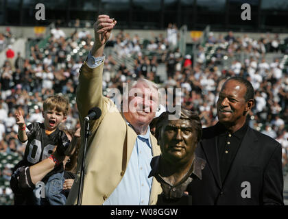 Ex Raiders pullman, emittente, e ora Hall of Famer John Madden trattiene il suo anello durante la Hall of Fame cerimonie prima che il gioco Raiders-Cardinals in McAfee Coliseum di Oakland, la California il 22 ottobre 2006. Ex Raider Gene Upshaw si erge a destra dietro Madden il busto. (UPI foto/Terry Schmitt) Foto Stock