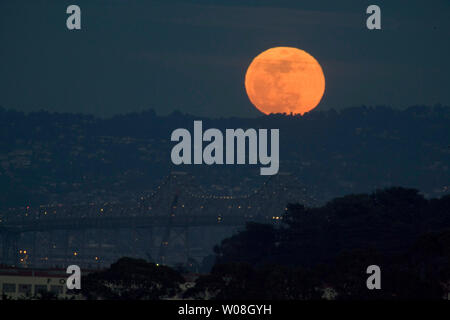 Ripetere - la luna piena sorge sopra il San Francisco-Oakland Bay Bridge visto dal Presidio di San Francisco il 3 marzo 2007. Sky gazers in tutto il mondo sono stati trattati per un'eclisse lunare ma era meglio visto in medio oriente. (UPI foto/Terry Schmitt) Foto Stock