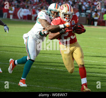 San Francisco 49ers LaMichael James (23) è afferrato dai delfini di Miami Chris Clemons nel terzo trimestre al Candlestick Park di San Francisco il 9 dicembre 2012. Il 49ers sconfitto i delfini 27-13. UPI/Terry Schmitt Foto Stock