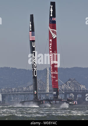 Emirates Nuova Zelanda (L) insegue Team Oracle USA sottovento in gara nove della Coppa America serie sulla Baia di San Francisco il 15 settembre 2013. Gli Stati Uniti ha vinto gara 9 e dividere la giornata con il Kiwi, che hanno preso il cuscinetto 10. Il nuovo East Span del Bay Bridge è in background. UPI/Terry Schmitt Foto Stock