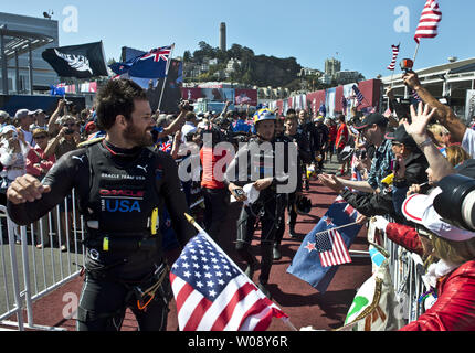 Team Oracle USA a piedi attraverso gli spettatori per il dock fuori cerimonia alla Coppa America Park a San Francisco il 17 settembre 2013. Eccessiva velocità di vento ha causato il rinvio della gara11 tra il challenger Emirates Nuova Zelanda e Defender Team Oracle USA. UPI/Terry Schmitt Foto Stock