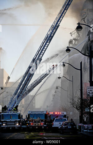 Vigili del fuoco versare acqua su un cinque allarme incendio in appartamenti in costruzione nel bacino di Cina quartiere di San Francisco il 11 marzo 2014. UPI/Terry Schmitt Foto Stock