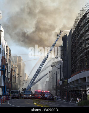 Vigili del fuoco versare acqua su un cinque allarme incendio in appartamenti in costruzione nel bacino di Cina quartiere di San Francisco il 11 marzo 2014. UPI/Terry Schmitt Foto Stock