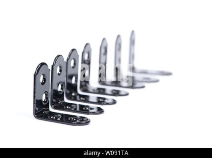 Gruppo di nero metallizzato fissatori di angolo. Montaggio ad angolo di metallo delle staffe angoli isolati su sfondo bianco Foto Stock