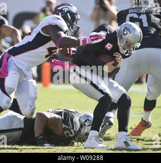 Oakland Raiders QB Derek Carr (R) è saccheggiata da Denver Broncos Shaquil Barrett per una perdita di sette metri nel terzo trimestre a O.co Coliseum di Oakland, la California il 11 ottobre 2015. I Broncos sconfitti i raider 16-10. Foto di Terry Schmitt/UPI Foto Stock