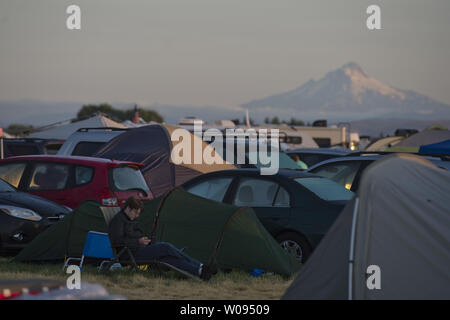 Un camper controlla il suo telefono cellulare wwith Mt. Cappa in distanza a Solartown a Madras, Oregon il 19 agosto 2017. Al fine di ospitare gli spettatori del 21 agosto eclisse solare totale e a trarre profitto dalla essendo nel percorso di totallity un campeggio è stata formata. Foto di Terry Schmitt/UPI Foto Stock