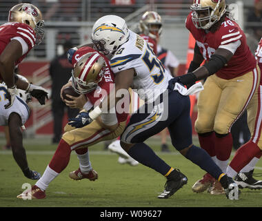 San Francisco 49ers QB C.J. Beathard (L) è licenziato per un cantiere di sette perdita da Los Angeles Chargers Nwosu Uchenna nel primo trimestre a Levi's Stadium di Santa Clara in California il giovedì 30 agosto, 2018. Foto di Terry Schmitt/UPI Foto Stock