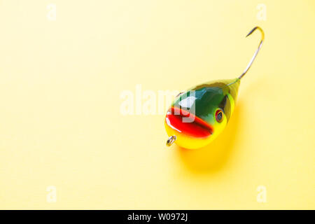 Ami da pesca e a forma di pesce esche su sfondo giallo con copia spazio. Messa a fuoco selettiva Foto Stock