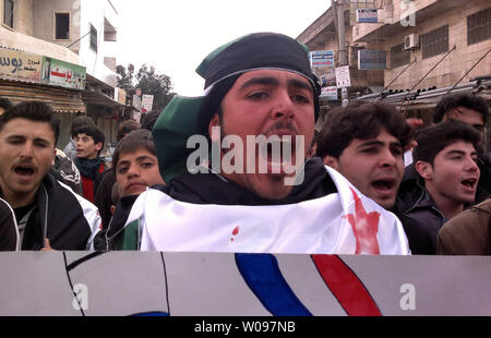 Dimostranti siriani tenere indicazioni durante una manifestazione di protesta contro la Siria il Presidente Bashar al-Assad in Kafranbel, Siria, 19 febbraio 2012. Opposizione siriana chiamato per la disobbedienza civile nella capitale Damasco, mentre l'Egitto ha ricordato il suo ambasciatore a Damasco, alla televisione di stato detto domenica, in ciò che sembrava essere la fase più recente di una serie di diplomatico arabo si muove per intensificare la pressione sul Presidente Bashar al-Assad, che sta cercando di schiacciare una rivolta popolare in Siria. UPI Foto Stock