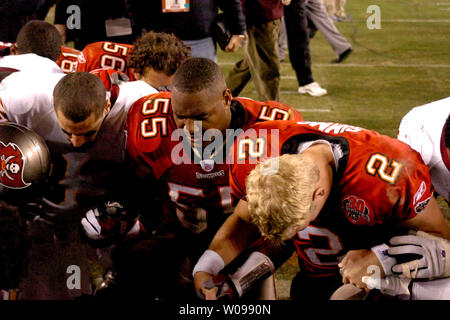 Washington Redskins' wide receiver James Thrash (83) Tampa Bay Buccaneers' linebacker Derrick Brooks (55) e il quarterback Chris Simms (2) pregare con i membri di entrambe le squadre dopo la Redskins battere i bucanieri 17-10 presso Raymond James Stadium Gennaio 7, 2006 a Tampa, FL. (UPI foto/Henry Kapulka) Foto Stock