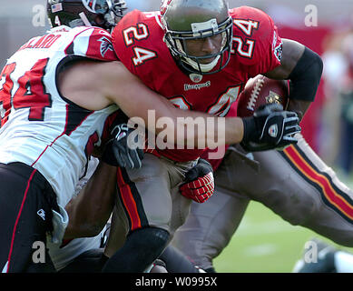 Tampa Bay Buccaneers' running back Carnell "Cadillac" Williams (24) viene affrontato da Atlanta Falcons' difensivo fine Josh germano reale (94) presso Raymond James Stadium di Tampa, Florida il 10 dicembre 2006. I falchi battere i bucanieri 17-6. (UPI foto/Cathy Kapulka) Foto Stock