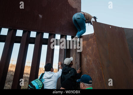 Con la crescente frustrazione per la lunghezza della procedura di asilo, i migranti scavalcare la recinzione di confine che divide gli Stati Uniti e il Messico il 2 dicembre 2018 vicino a Las Playas de Tijuana, Messico. Foto di Ariana Drehsler/UPI Foto Stock