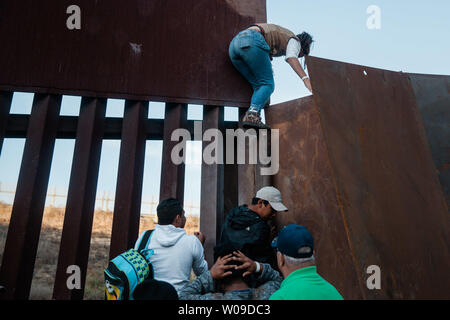 Con la crescente frustrazione per la lunghezza della procedura di asilo, i migranti scavalcare la recinzione di confine che divide gli Stati Uniti e il Messico il 2 dicembre 2018 vicino a Las Playas de Tijuana, Messico. Foto di Ariana Drehsler/UPI Foto Stock