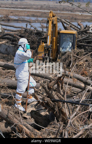 Polizia giapponese chimici indossare tute di protezione ricerca di vittime all'interno della 20 km di raggio attorno a Fukushima Dai-ichi centrale nucleare a Minamisoma, Fukushima prefettura, Giappone, il 15 aprile 2011. Un terremoto e dal conseguente tsunami del marzo 11 case distrutte, ha provocato migliaia di vittime e causato una catastrofe nucleare. UPI/Keizo Mori Foto Stock