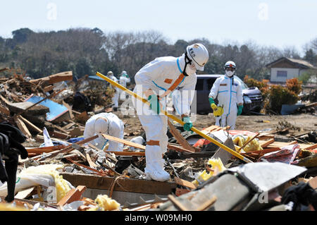 Polizia giapponese chimici indossare tute di protezione ricerca di vittime all'interno della 20 km di raggio attorno a Fukushima Dai-ichi centrale nucleare a Minamisoma, Fukushima prefettura, Giappone, il 15 aprile 2011. Un terremoto e dal conseguente tsunami del marzo 11 case distrutte, ha provocato migliaia di vittime e causato una catastrofe nucleare. UPI/Keizo Mori Foto Stock