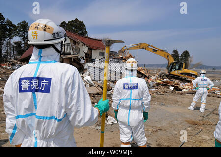 Polizia giapponese chimici indossare tute di protezione ricerca di vittime all'interno della 20 km di raggio attorno a Fukushima Dai-ichi centrale nucleare a Minamisoma, Fukushima prefettura, Giappone, il 15 aprile 2011. Un terremoto e dal conseguente tsunami del marzo 11 case distrutte, ha provocato migliaia di vittime e causato una catastrofe nucleare. UPI/Keizo Mori Foto Stock