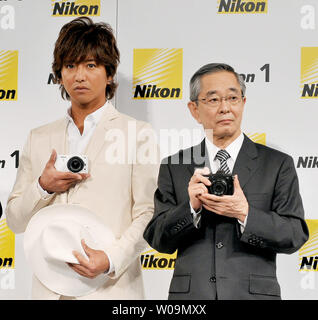 Cantante giapponese Takuya Kimura(L) e Makoto Kimura, Presidente della Nikon Corporation., posa con la nuova fotocamera digitale Nikon '1' nel corso di una conferenza stampa a Tokyo in Giappone, il 21 settembre 2011. UPI/Keizo Mori Foto Stock