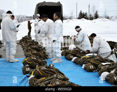 Membro del Giappone terra Forza di Autodifesa prepararsi per scendere da paracadute durante il giunto esercitazione militare " vento del nord 2' CON GLI STATI UNITI Esercito Alaska 4-25 iBCT al Yausubetsu Area Formazione in Hokkaido, Giappone, il 17 febbraio 2015. Foto di Keizo Mori/UPI Foto Stock