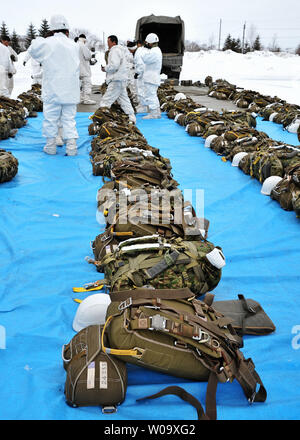 Membro del Giappone terra Forza di Autodifesa prepararsi per scendere da paracadute durante il giunto esercitazione militare " vento del nord 2' CON GLI STATI UNITI Esercito Alaska 4-25 iBCT al Yausubetsu Area Formazione in Hokkaido, Giappone, il 17 febbraio 2015. Foto di Keizo Mori/UPI Foto Stock