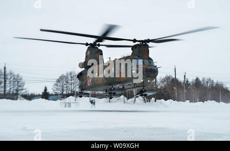 In Giappone la massa di autodifesa della forza CH-47J Chinook decollare per scendere da paracadute durante il "Vento del Nord 2' CON GLI STATI UNITI Esercito Alaska 4-25 iBCT al Yausubetsu Area Formazione in Hokkaido, Giappone, il 17 febbraio 2015. Foto di Keizo Mori/UPI Foto Stock