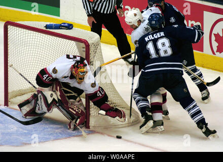 Senatori di Ottawa goalie Patrick Lalime tenta di agguantare il puck come senatori defenceman Greg de Vries si prende cura di Toronto Maple Leafs' Chad Kilger durante il secondo periodo di azione nel gioco 5 del loro serie nel primo round del NHL Playoffs presso la Air Canada Centre a Toronto in Canada su apr. 16, 2004. Le foglie sconfitto i senatori 2-0 per portare la serie 3-2. (UPI foto/Christine masticare) Foto Stock