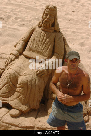 Un intraprendente artista crea le sculture di sabbia sulla spiaggia fuori La Croisette a Cannes, Francia, 14 maggio 2004. La Croisette, Cannes" ben noto lungomare, è stato riempito con i turisti e gli appassionati di cinema che hanno buttato giù il denaro all'artista nell'apprezzamento del suo lavoro. (UPI foto/Christine masticare) Foto Stock