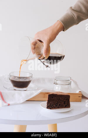 La produzione di birra nel caffè di gocciolamento. Passo per passo le istruzioni di cottura. Il caffè è pronto. Barista versando preparato del caffè in tazza Foto Stock